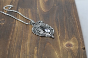 Detailed close-up of hip-hop wolf head pendant with sparkling zircon on wood background