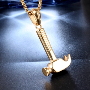 Detailed macro shot of a gold-plated hammer pendant with polished finish and box chain