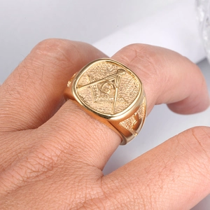 Macro detail of men's gold Freemasonry signet ring with engraved compass and G symbol