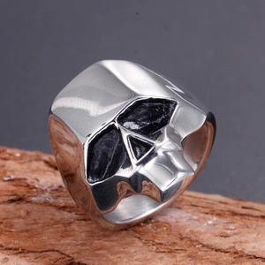 Gothic skull ring for men in stainless steel with black obsidian stones on wood