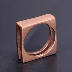 Macro shot of square stainless steel ring with a brushed bronze finish and matte texture