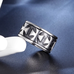Bague croix vintage en acier inoxydable pour homme avec finition oxydée sur fond bleu