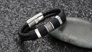 Macro detail of men's double braided black leather bracelet with steel magnetic clasp