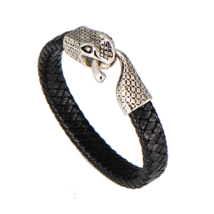 Detailed view of punk style braided leather bracelet with carved metal snake head clasp