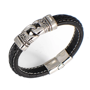 Détail du bracelet en cuir tressé noir avec fermoir magnétique en métal gravé