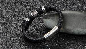 Detail of multi-layer black braided leather bracelet with stainless steel magnetic clasp