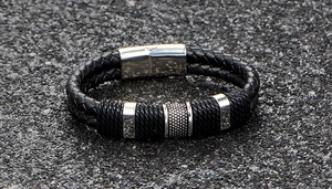 Close-up of black braided leather bracelet for men with textured silver metal beads