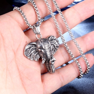 Silver stainless steel Thai elephant pendant necklace with detailed carving shown in hand