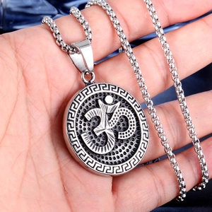 Détail macro du pendentif Om en argent avec bordure grecque sur collier en acier