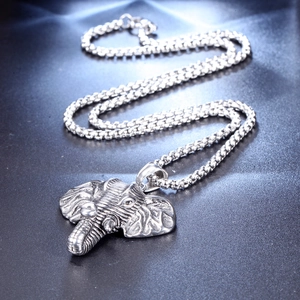 Detail shot of vintage silver elephant head pendant with intricate engraved textures