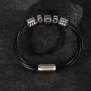 Bracelet multicouche en cuir tressé noir pour homme avec breloques argentées sur roche