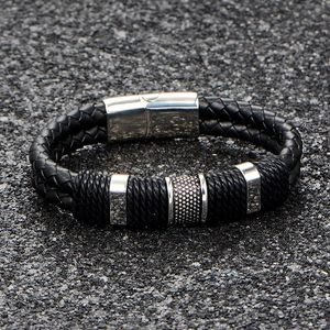 Men's double-braided leather bracelet with magnetic steel clasp on stone background
