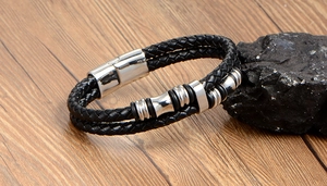 Close-up of black braided leather men's bracelet with silver magnetic steel clasp