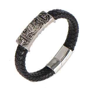 Détail du bracelet en cuir tressé noir avec plaque vintage argentée et fermoir magnétique