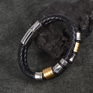 Men's braided black leather bracelet with gold and silver metal charms on stone