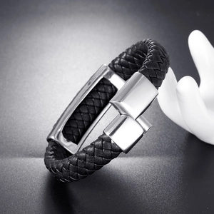 Bracelet tressé en cuir pour homme avec fermoir poli en acier inoxydable sur fond sombre