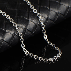 Collier chaîne en O en acier inoxydable 316 poli sur une texture de cuir noir premium