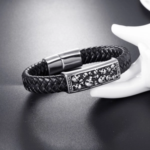 Détail du bracelet punk en cuir tressé avec relief de crâne et fermoir magnétique en acier