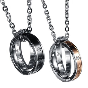 Macro shot of interlocking couple necklaces with cz stones and love eternity engraving