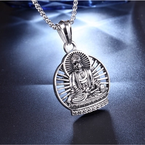 Detailed close-up of a vintage silver Buddha pendant with intricate carvings and bead chain