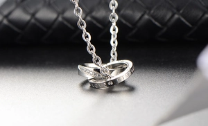 Détail du pendentif double anneau en argent avec zircons et gravure Love Eternal élégante