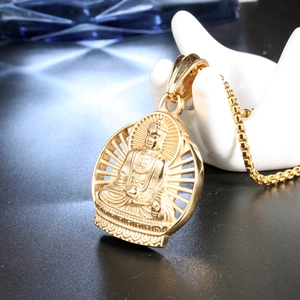 Macro shot of gold Buddha relief pendant on box chain displayed on white ceramic hand prop