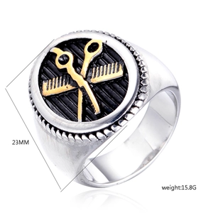 Detail of barber ring showing gold scissors and comb relief on black shield surface