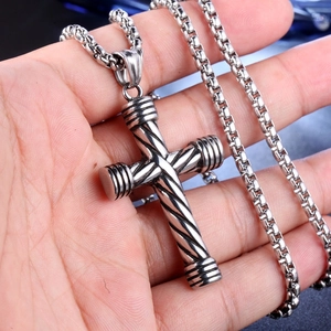 Detail of silver twisted cross pendant on box chain, punk style jewelry for men