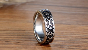 Macro shot of retro stainless steel ring with black engraved mystical runes