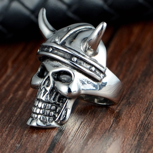 Close-up of vintage silver-tone Viking skull ring with horns and rustic metal texture