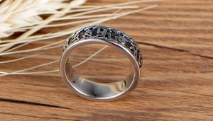 Detailed macro shot of vintage silver stainless steel ring with Sanskrit engraving
