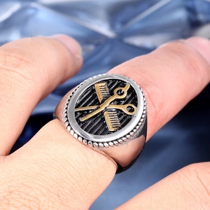 Men's two-tone stainless steel signet ring featuring embossed barber scissors and comb