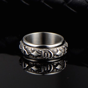 Vue macro d'une bague rotative en acier inoxydable avec symboles gravés et reflet