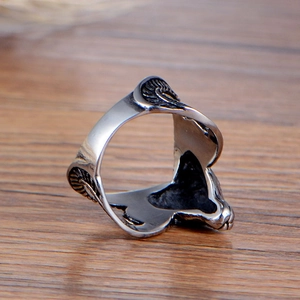 Vintage punk style goat head ring in oxidized titanium steel on a natural wood surface