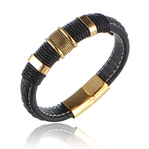 Detail of black braided leather bracelet with gold metal rings and magnetic clasp