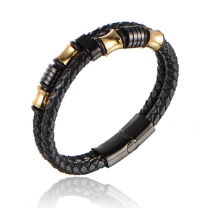 Detail of double-layered black leather bracelet with gold and black magnetic clasp