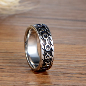 Retro stainless steel ring for men with Buddhist mantra engraving on a wood background