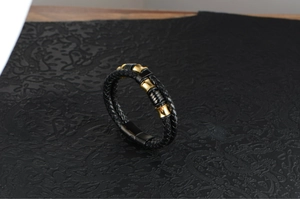 Close-up of double-layer black braided leather bracelet with golden steel magnetic clasp