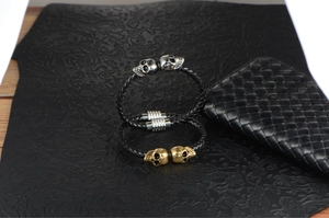 Detail of hand-woven leather bracelets with skull charms and magnetic steel clasps