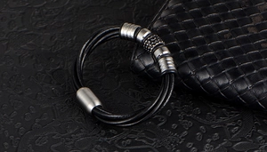 Macro shot of men's braided leather bracelet featuring stainless steel magnetic clasps