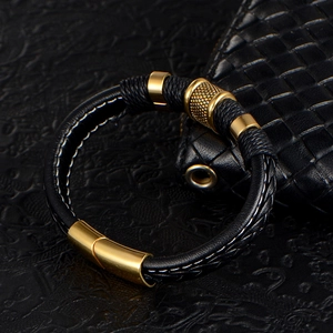 Men's black braided leather bracelet featuring gold knurled metal accents and magnetic clasp