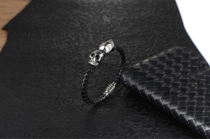 Close-up of handmade braided leather bracelet with silver skull details and metal clasp
