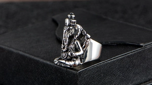 Detailed close-up of a vintage silver Ganesha ring for men on a black textured box