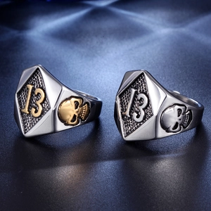 Detailed close-up of retro punk skull rings with number thirteen on a dark background