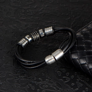 Men's multi-layer braided leather bracelet with silver metal beads on black leather background