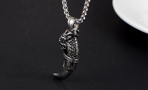 Vue détaillée du pendentif tête de dragon et corne en acier titane argenté vieilli rétro