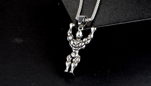 Macro shot of silver-toned muscular male pendant with detailed stainless steel textures