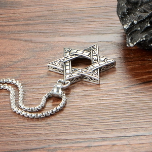Macro detail of Hexagram totem pendant with vintage engravings on dark wood background