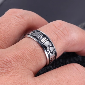 Vue rapprochée d'une bague large en acier inoxydable vintage avec émail noir et cœur