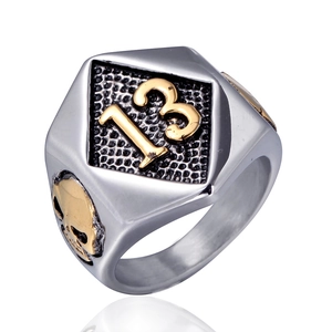 Detailed macro of men's stainless steel biker ring with gold 13 signet and skull design